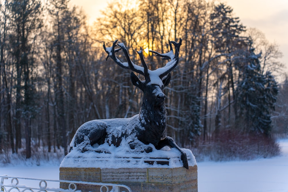 a statue of a deer in the snow