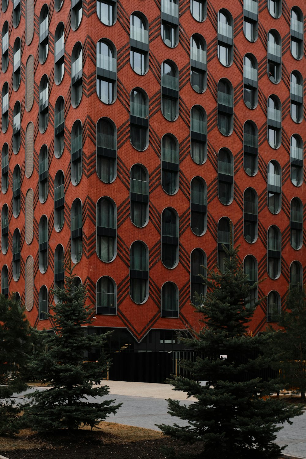 a large red building with many windows and trees in front of it