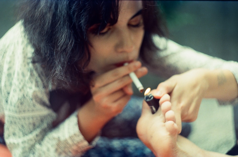a woman smoking a cigarette while sitting down