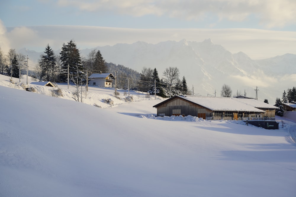 ein schneebedeckter Hügel mit einem Haus in der Ferne