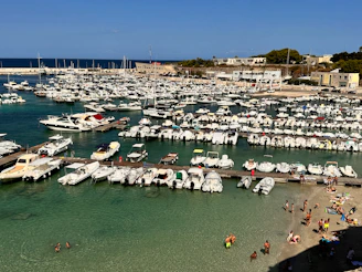 Panoramic shot of Urla marina filled with sleek yachts under a clear blue sky.