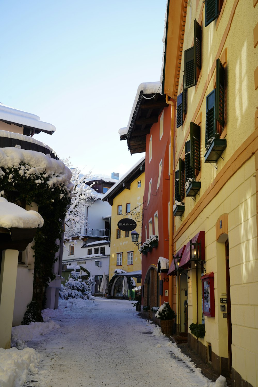 a narrow street with snow on the ground