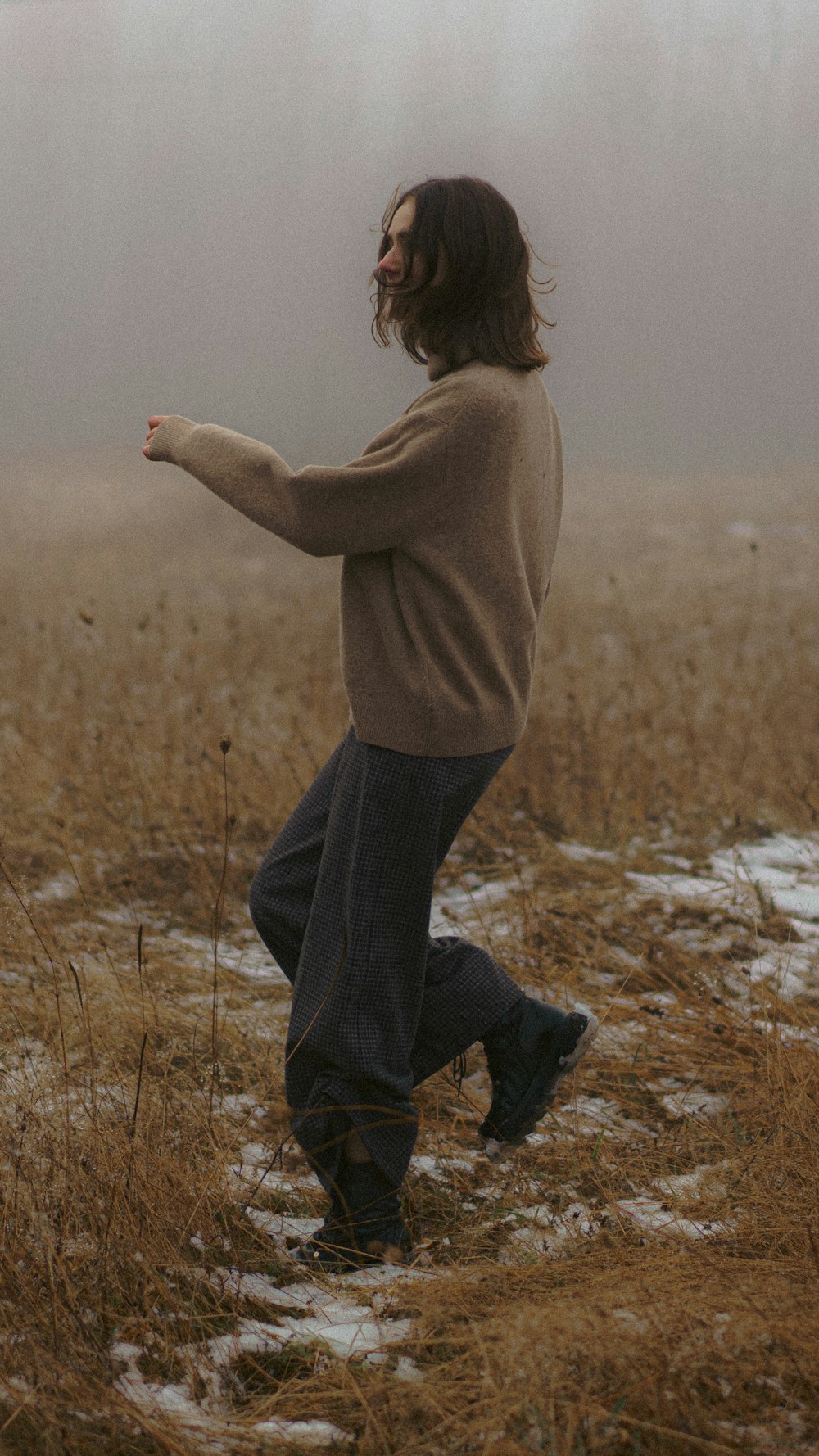 a man standing in a foggy field holding a frisbee