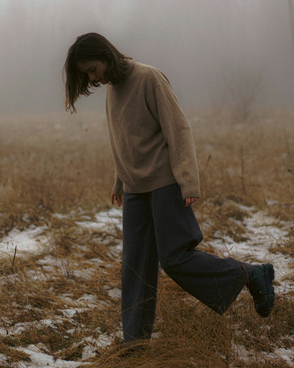 a woman walking through a foggy field