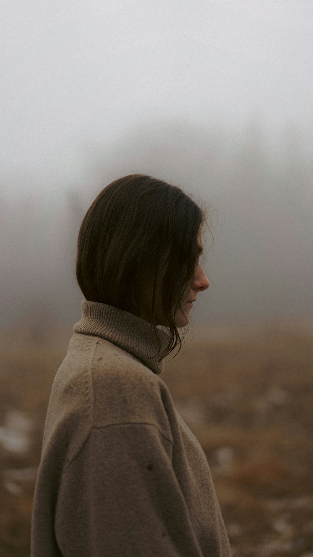 a woman standing in a foggy field