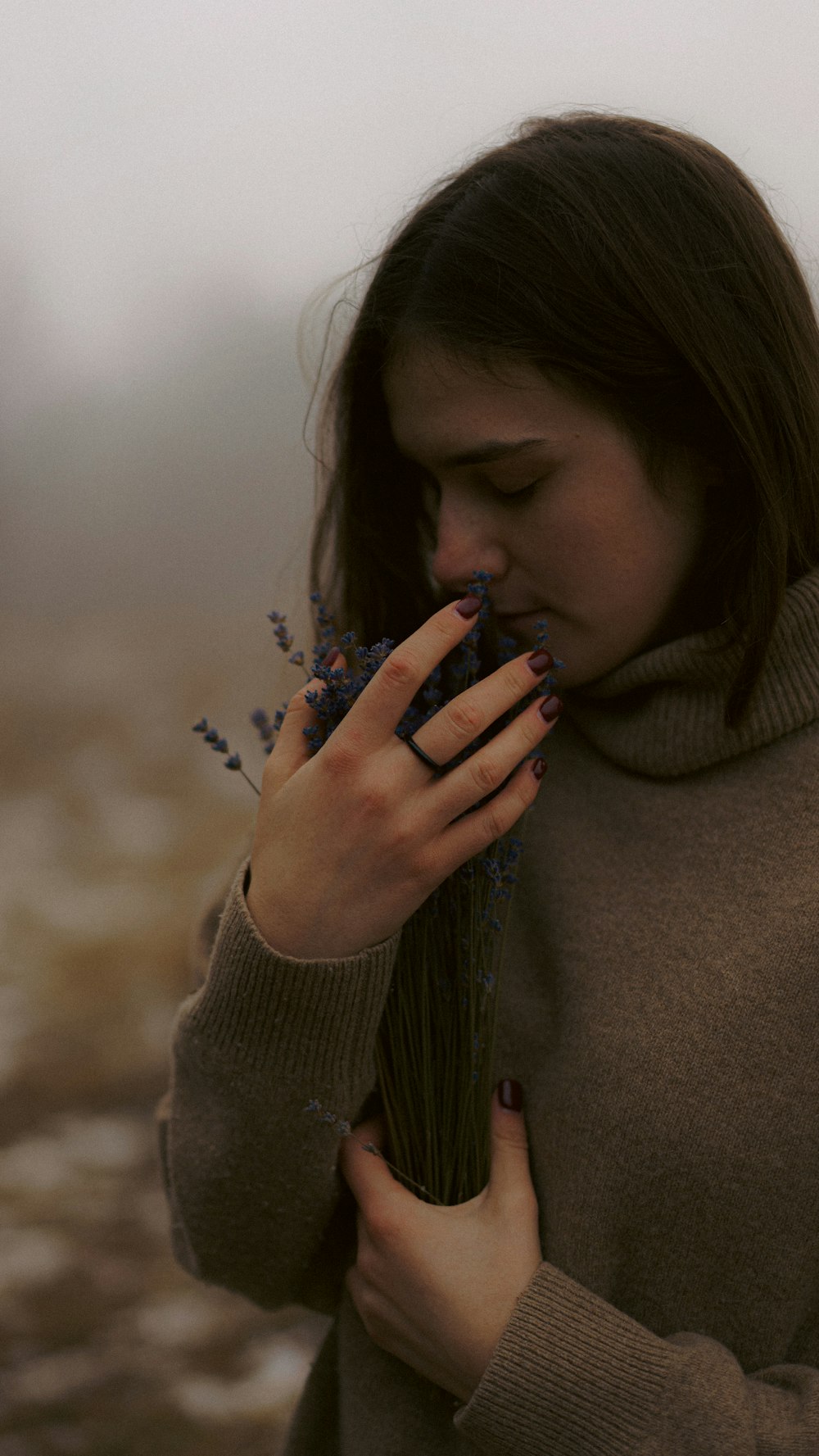 a woman holding a bunch of flowers in her hands