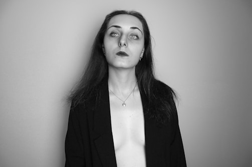 A moody black and white portrait of a model wearing a velvet jacket.