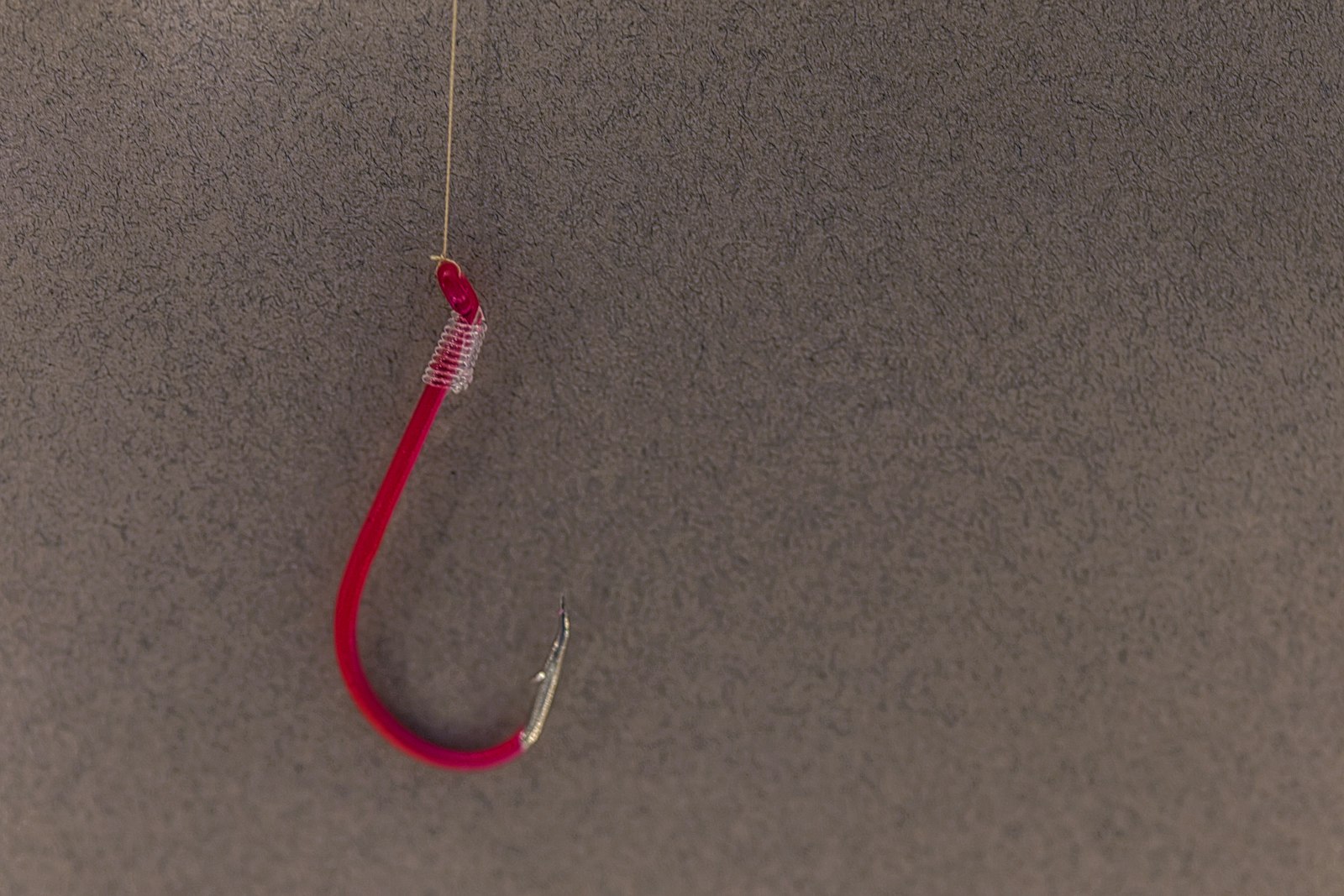 A fishing hook on a plain background