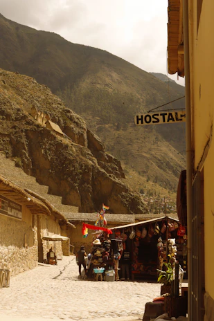 A rustic village street lined with colorful houses and lively market stalls bursting with fresh produce.