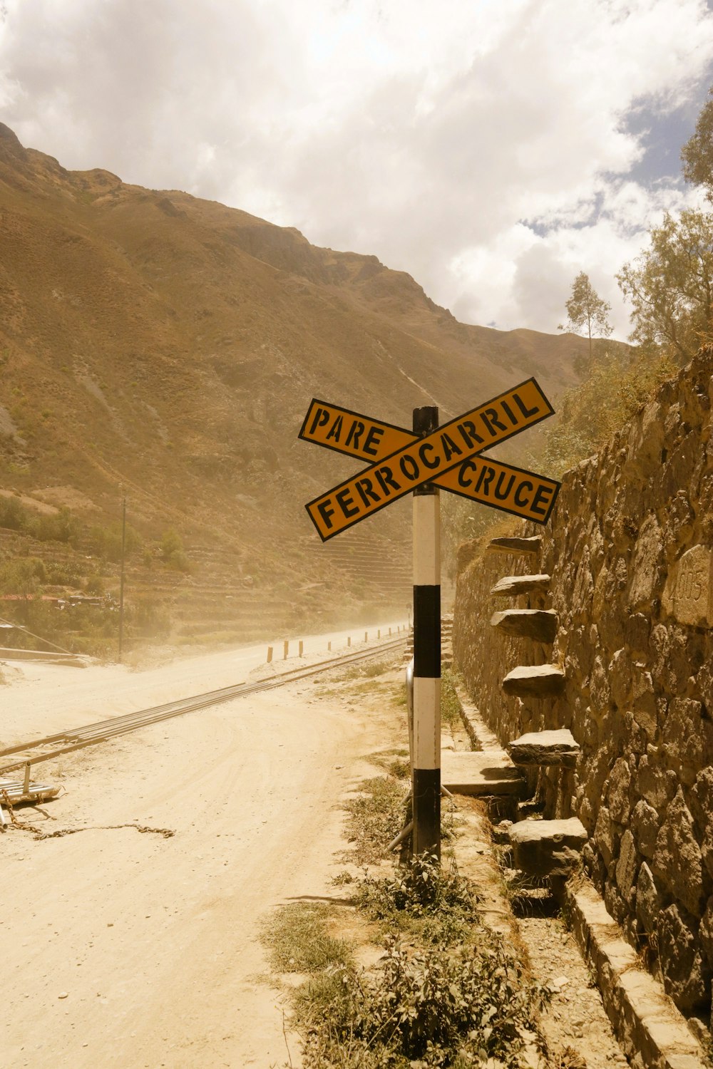 a street sign on the side of a dirt road