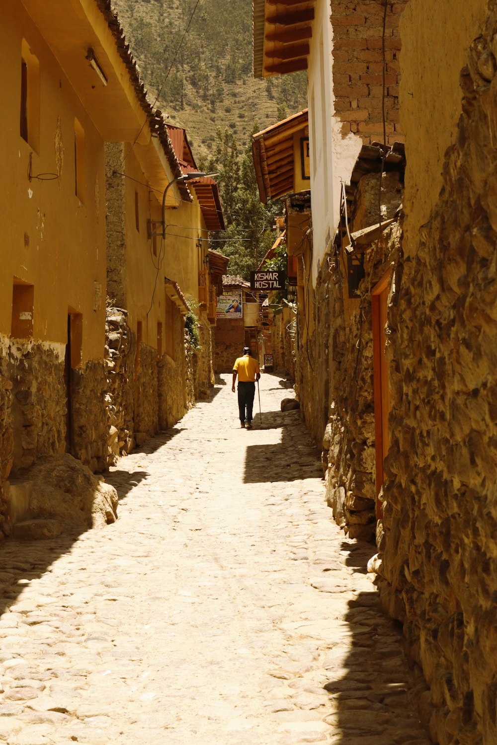 a person walking down a street with a yellow umbrella