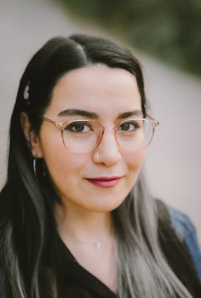 a woman wearing glasses and a black shirt
