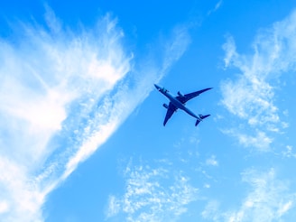 An airplane captured mid-flight against a clear blue sky.