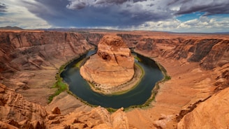 A serene view of the horseshoe-shaped bend in the Strawberry River surrounded by lush Ozark foothills under a clear blue sky.