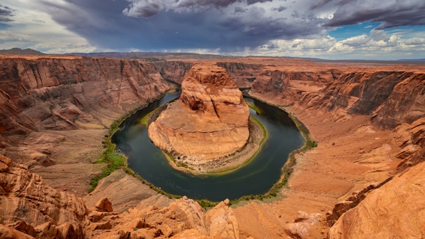A serene view of the horseshoe-shaped bend in the Strawberry River surrounded by lush Ozark foothills under a clear blue sky.
