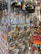 A display of colorful souvenirs featuring the word 'Barcelona' in various designs, alongside vibrant ceramic items. The image showcases keychains, magnets, and decorative pieces with artistic representations of landmarks. Rows of brightly painted bowls and dishes add to the vibrant atmosphere.