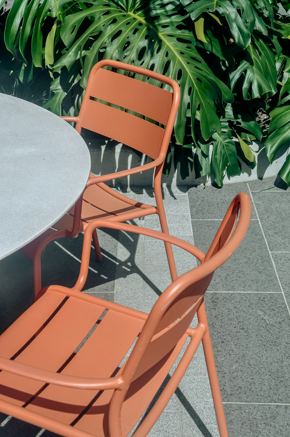 two orange chairs sitting next to a table