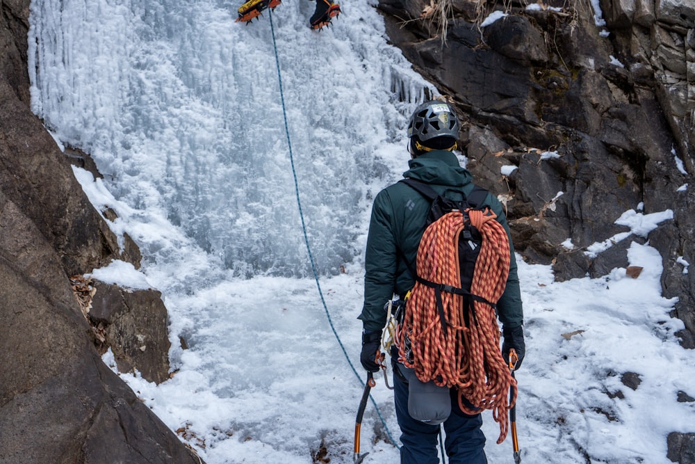 a man climbing up a mountain with a backpack