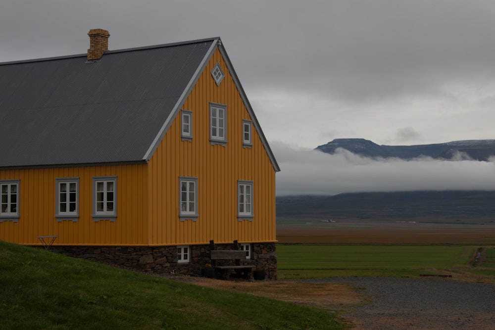 a yellow house with a mountain in the background