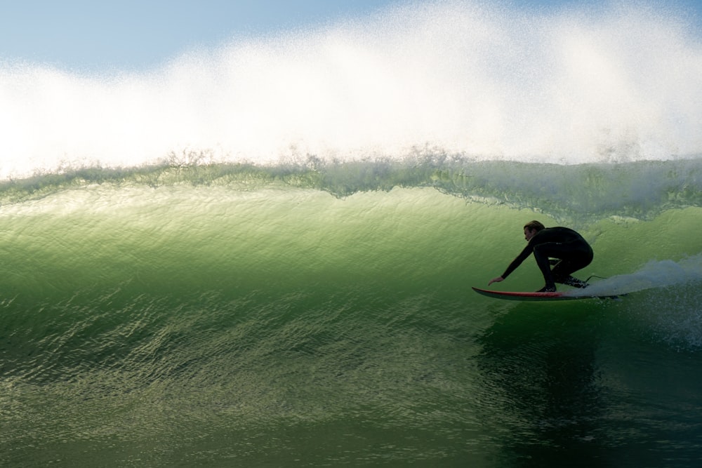 um homem surfando uma onda em cima de uma prancha de surf