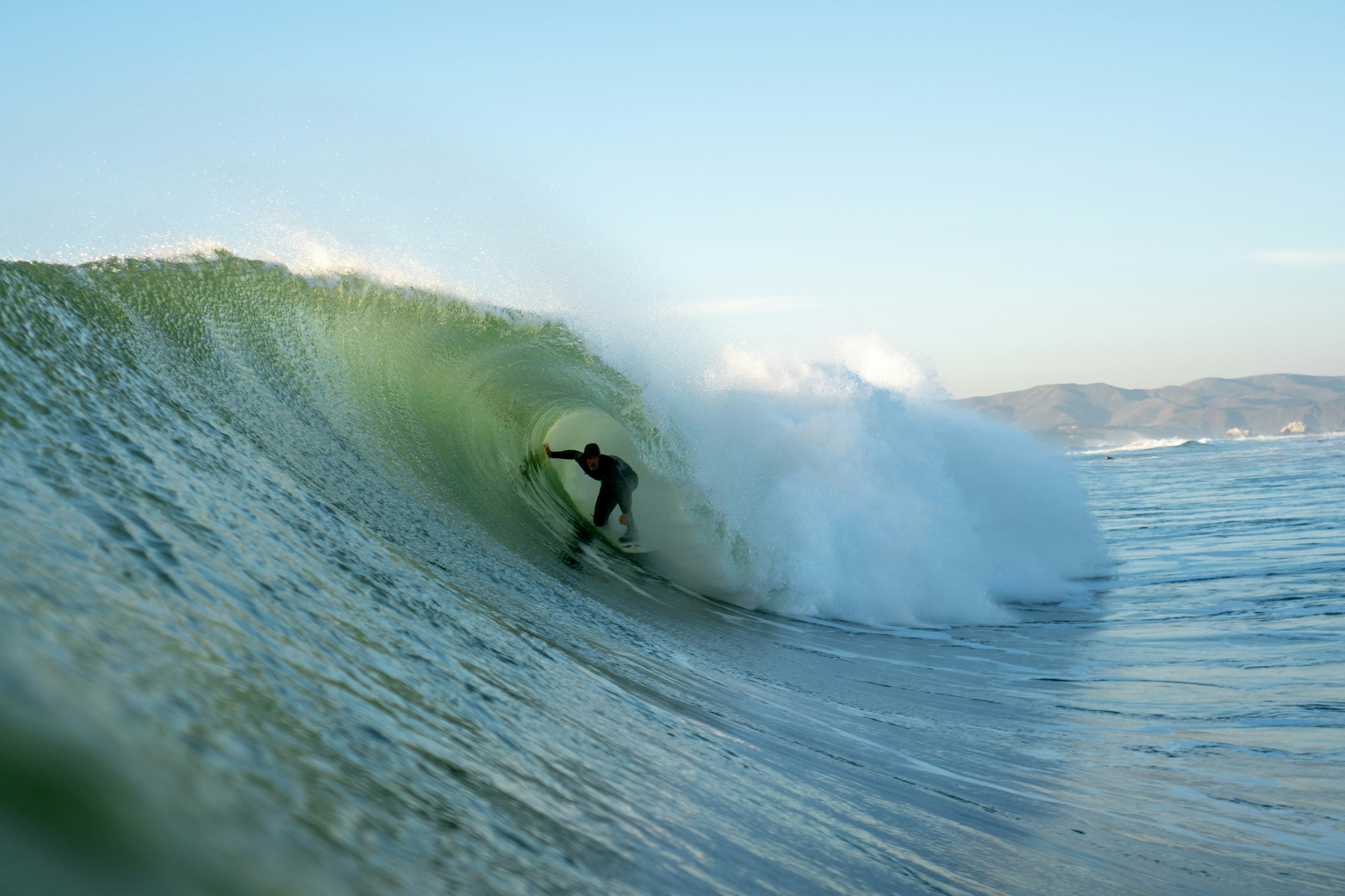 a man riding a wave on top of a surfboard