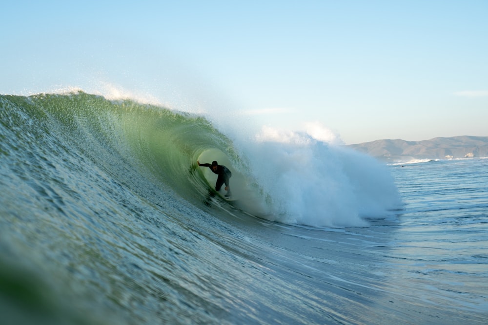 un homme chevauchant une vague sur une planche de surf