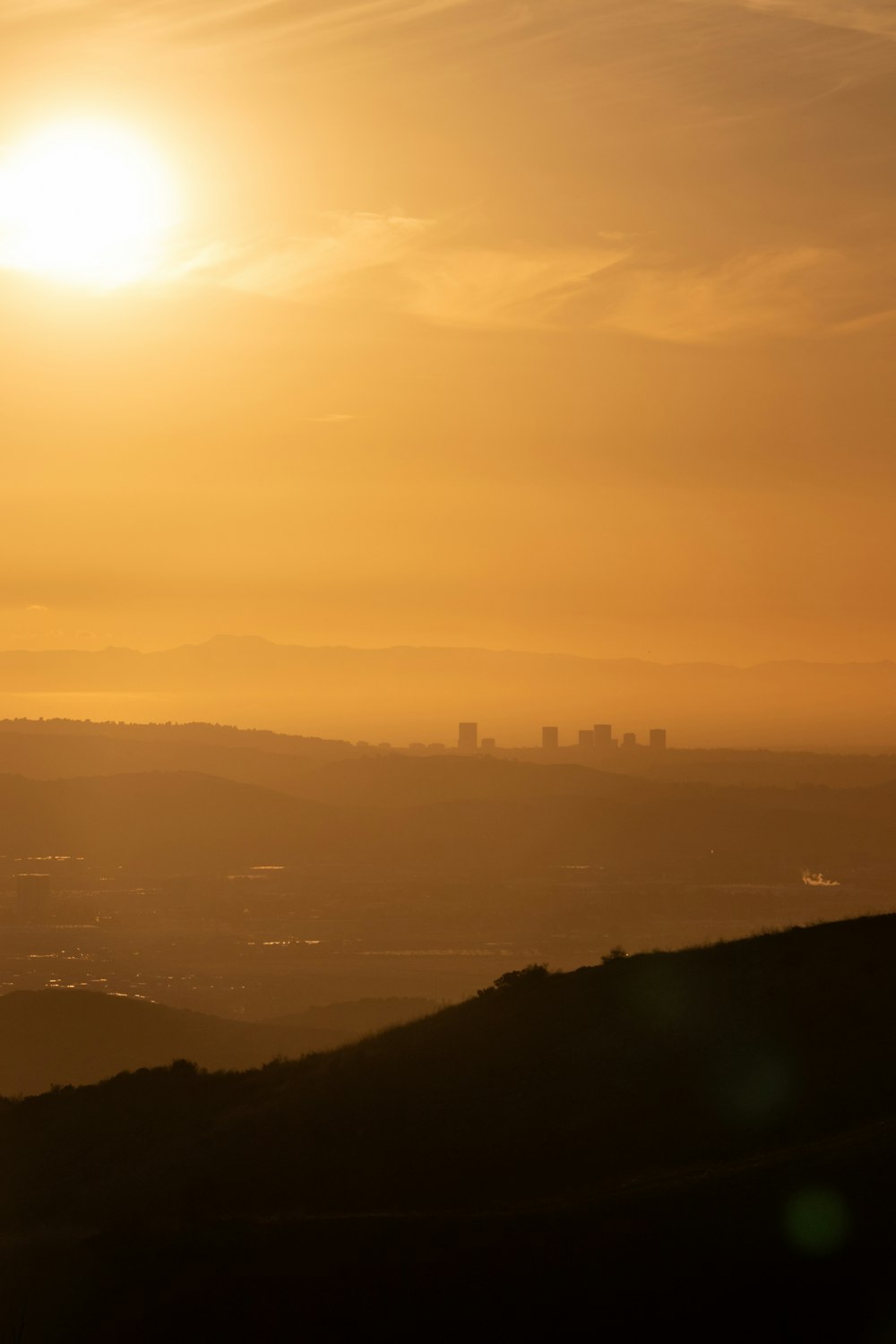 the sun is setting over the horizon of a city