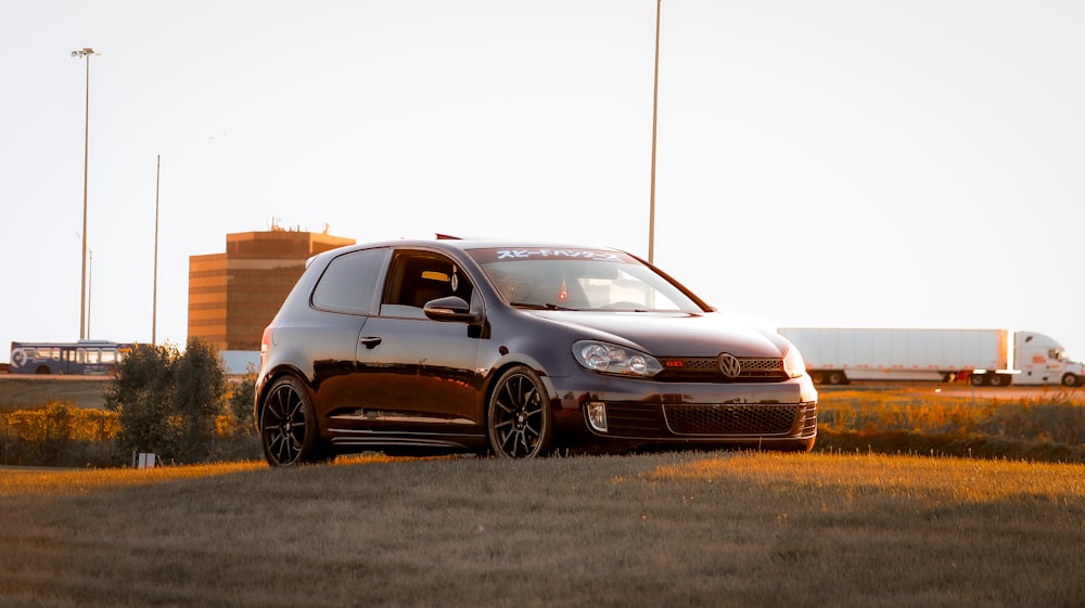 a small black car parked in a field