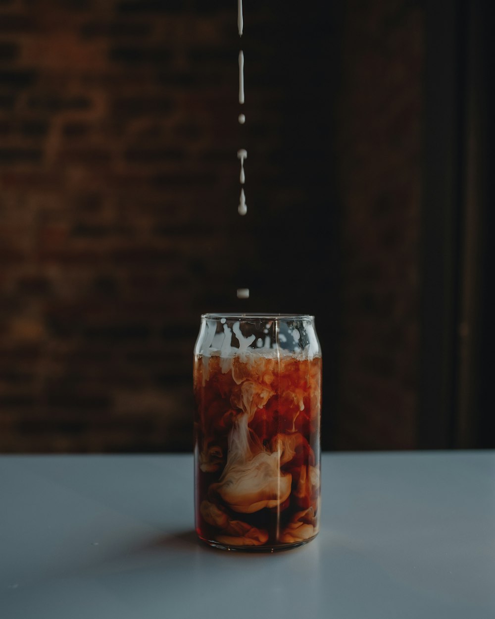 a can of soda being poured into a glass