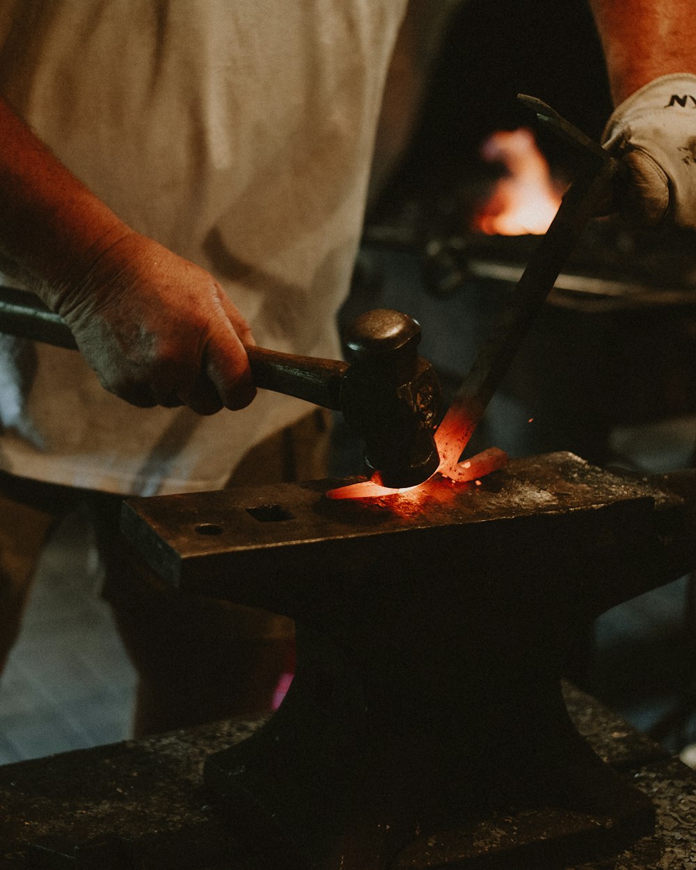 a man working on a piece of metal with a hammer