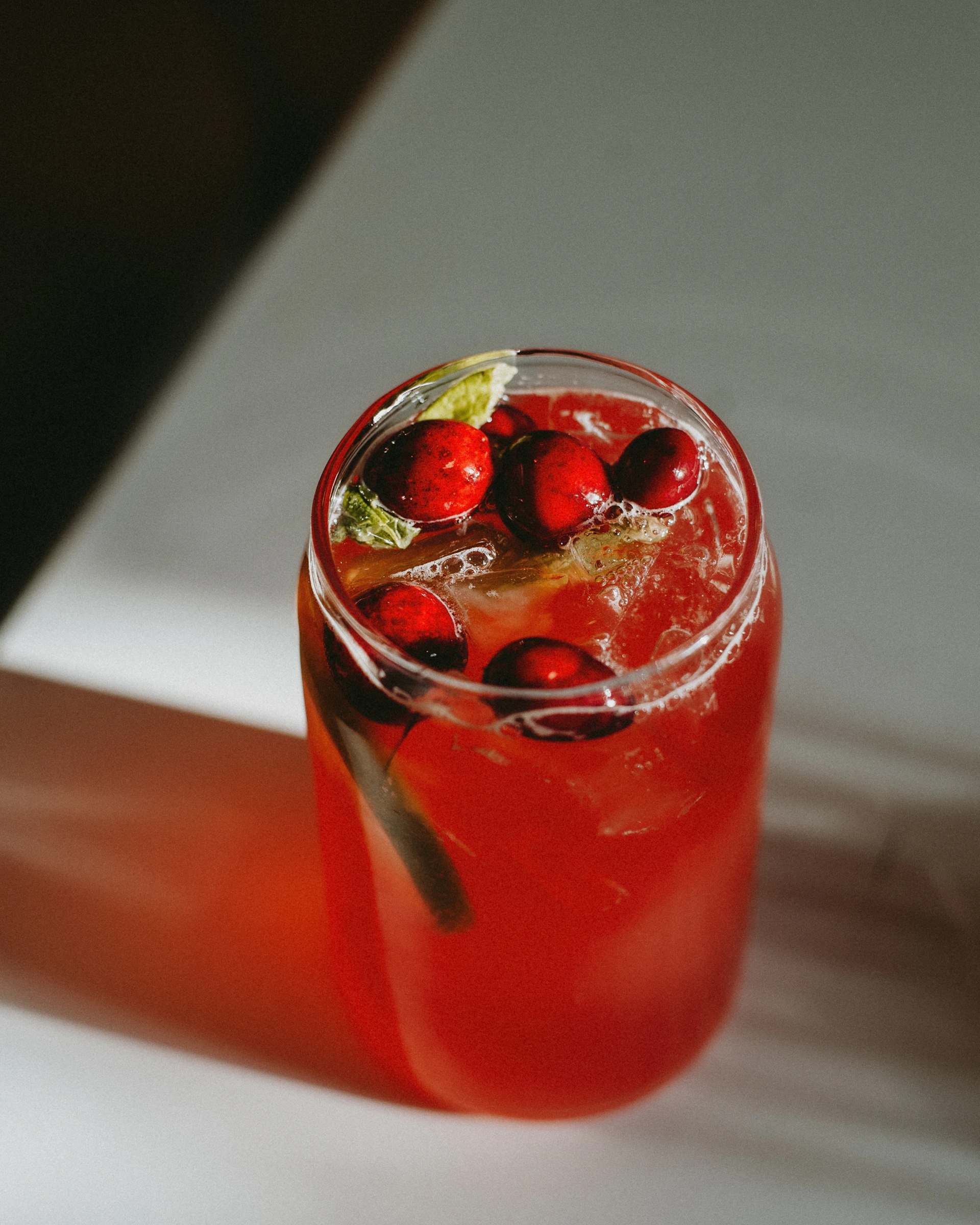 a red drink with cherries in a glass