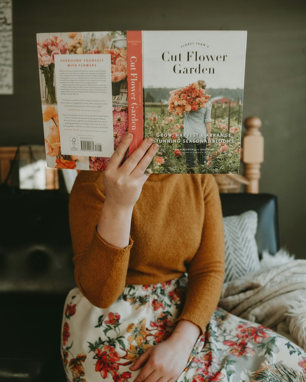 a woman sitting on a bed reading a book