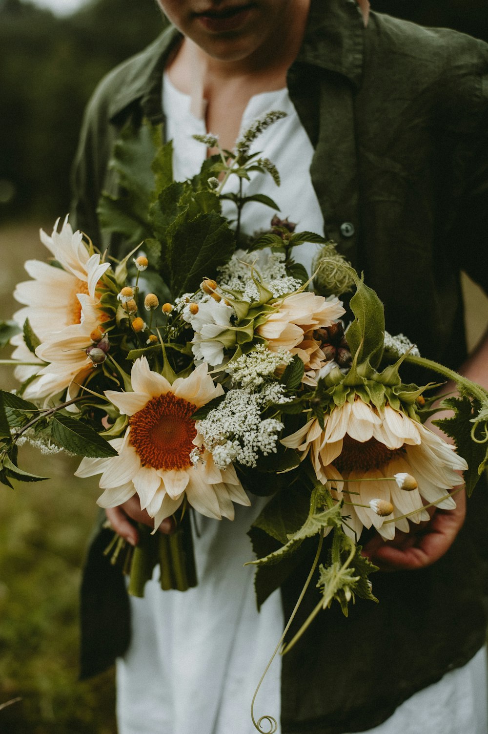 a woman holding a bouquet of flowers in her hands