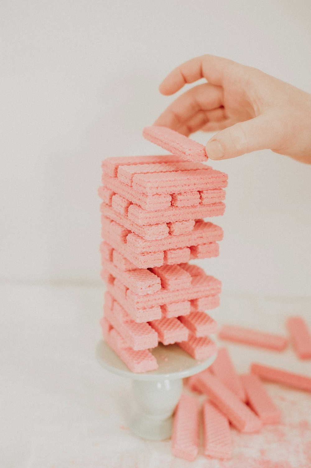 a stack of pink marshmallows being held by a hand