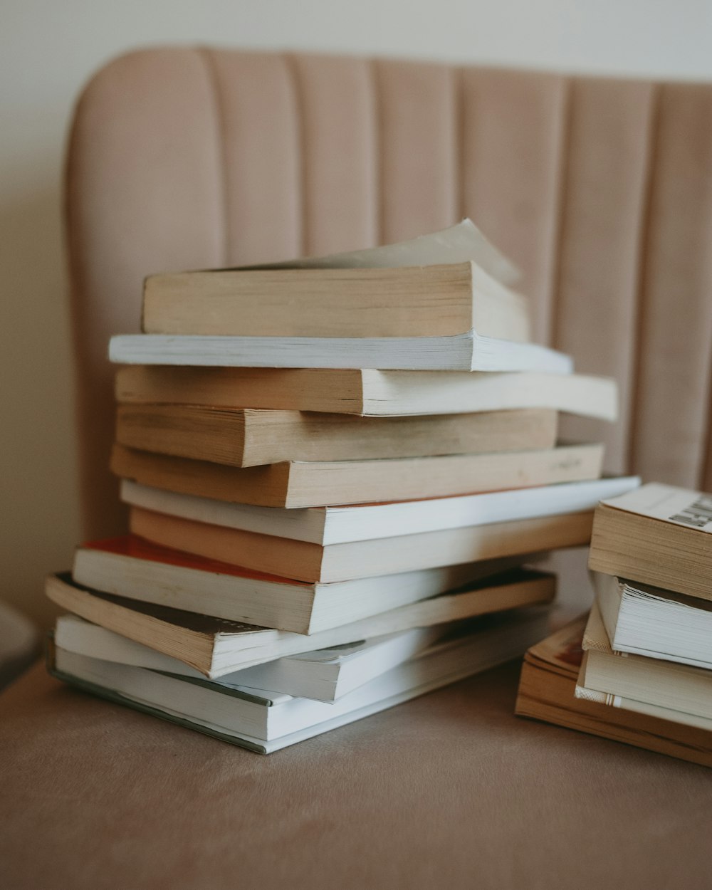 a stack of books sitting on top of a couch