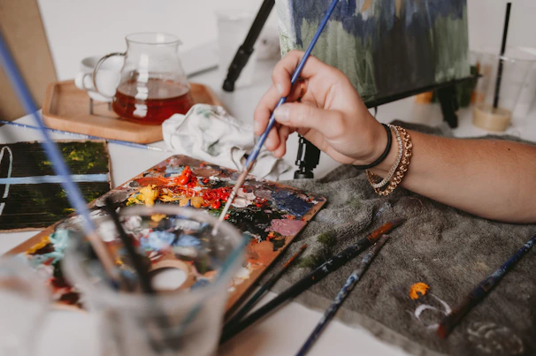 Close-up of colorful paintbrushes and palettes used during a therapy workshop.