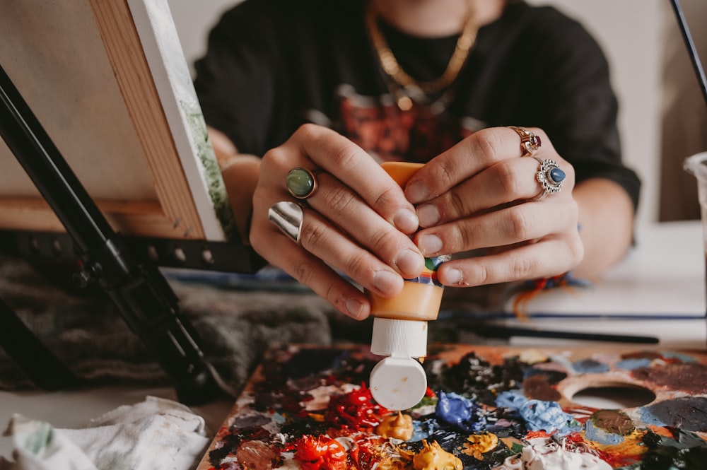 a woman is painting on a canvas with her hands