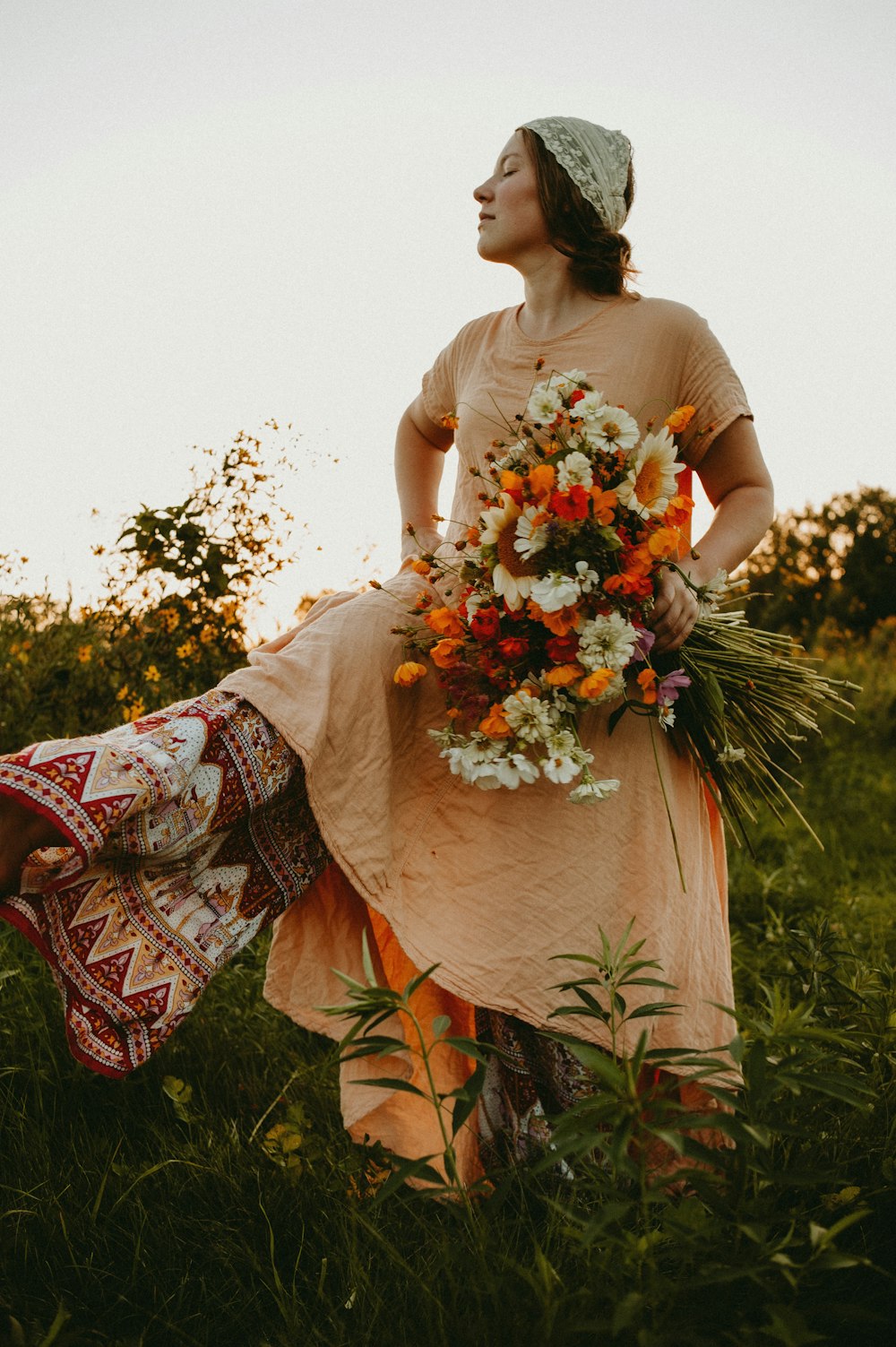 a woman in a dress holding a bouquet of flowers