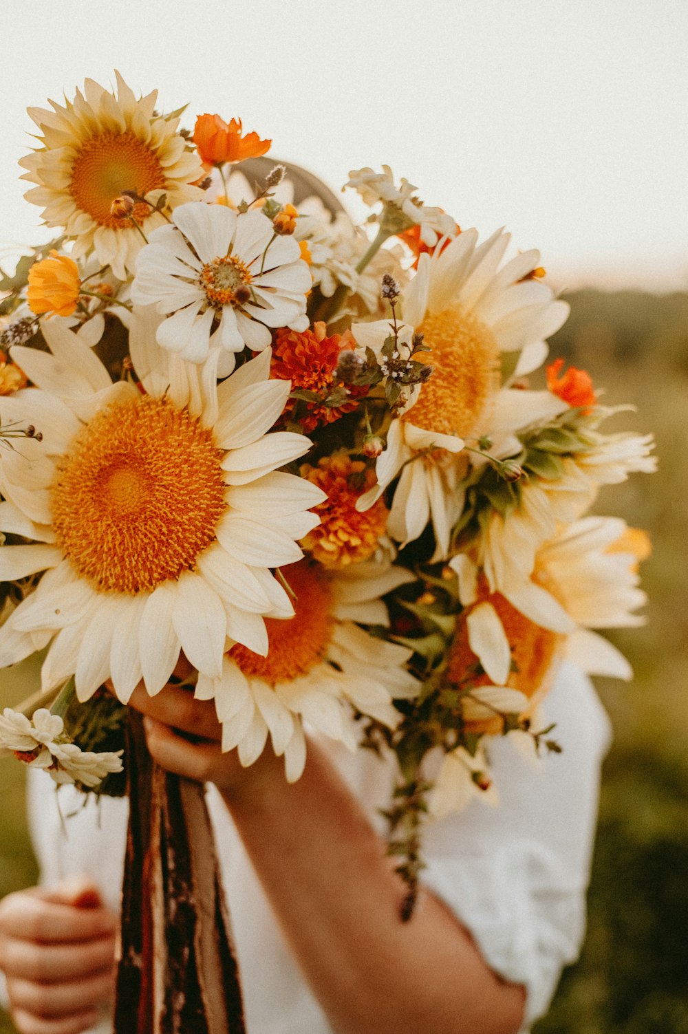 una persona che tiene in mano un mazzo di fiori