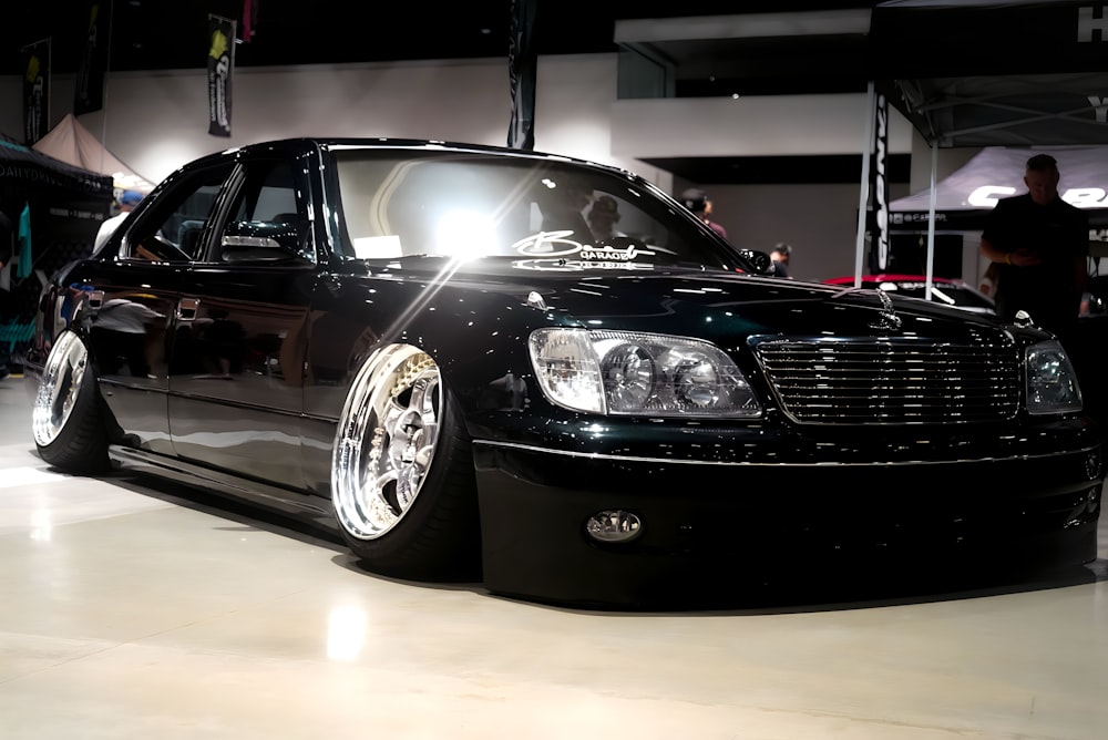 a black car is parked in a showroom