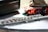 A close-up view of a silver flute placed on a textured surface beside a dark box and festive decorations.