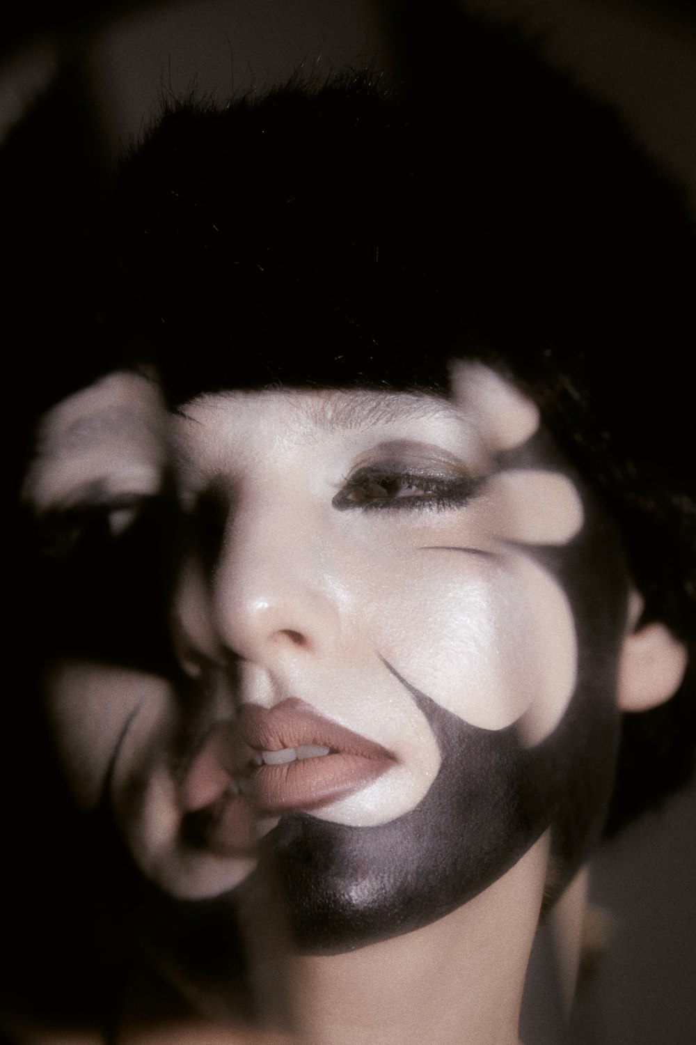 a woman with black and white face paint on her face