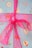 A festive wrapping paper decorated with various holiday motifs such as candy canes, donuts with sprinkles, gingerbread men, and Santa Claus faces. The paper is predominantly blue and is tied with a shiny pink ribbon.