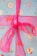 A festive wrapping paper decorated with various holiday motifs such as candy canes, donuts with sprinkles, gingerbread men, and Santa Claus faces. The paper is predominantly blue and is tied with a shiny pink ribbon.