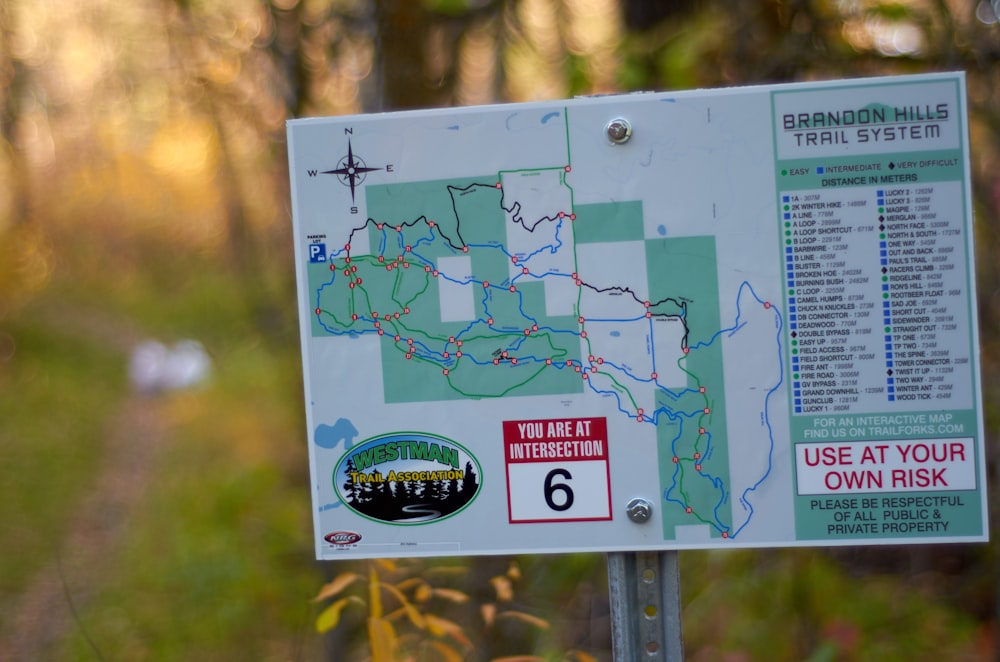 a sign with a map on it in the woods