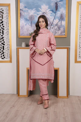A stylish young woman wearing a contemporary kurti with elegant patterns, smiling in a sunlit boutique setting.