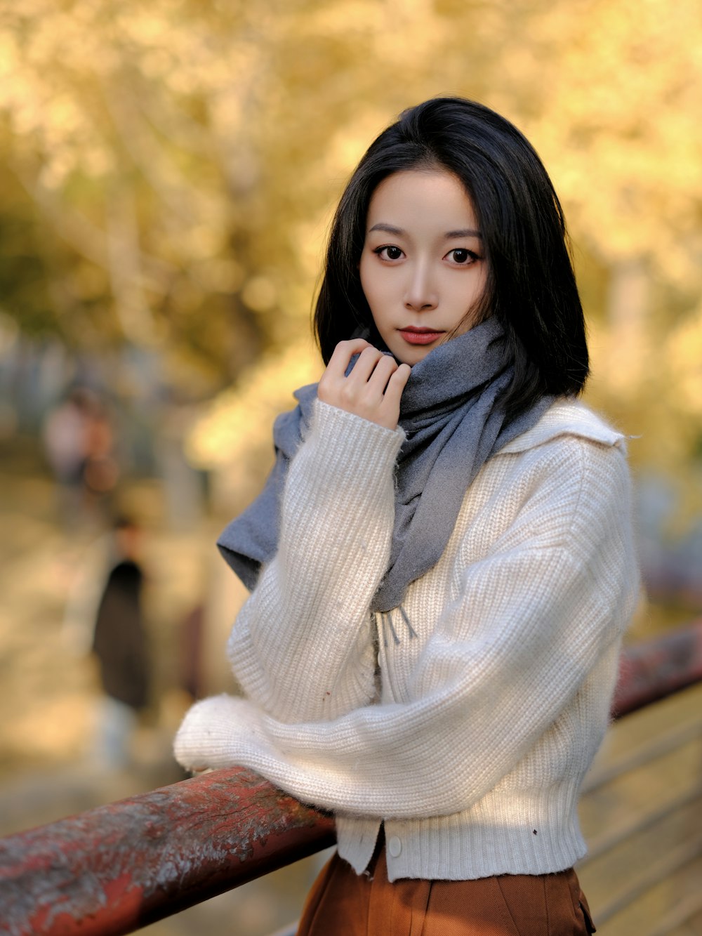 a woman is posing for a picture while leaning on a rail