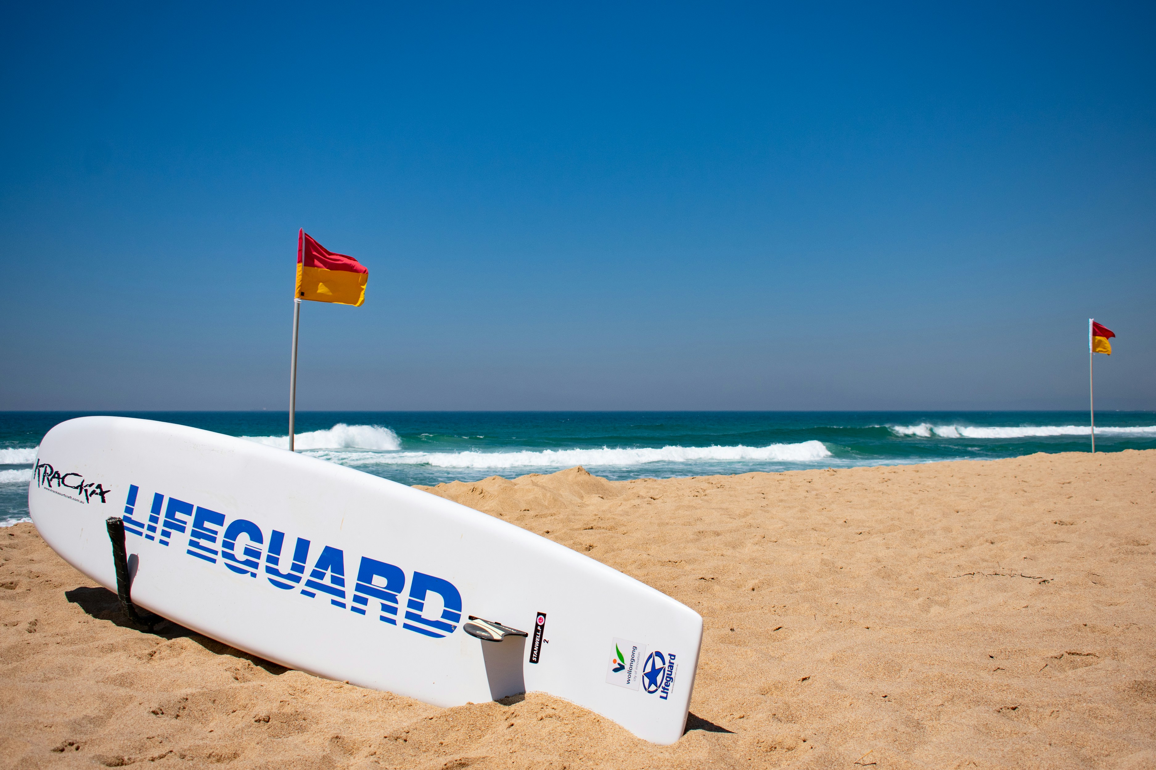 Australian lifeguard surfboard with red and yellow beach flags
