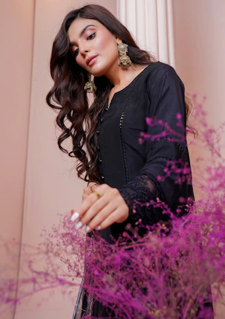 a woman standing in front of a purple plant