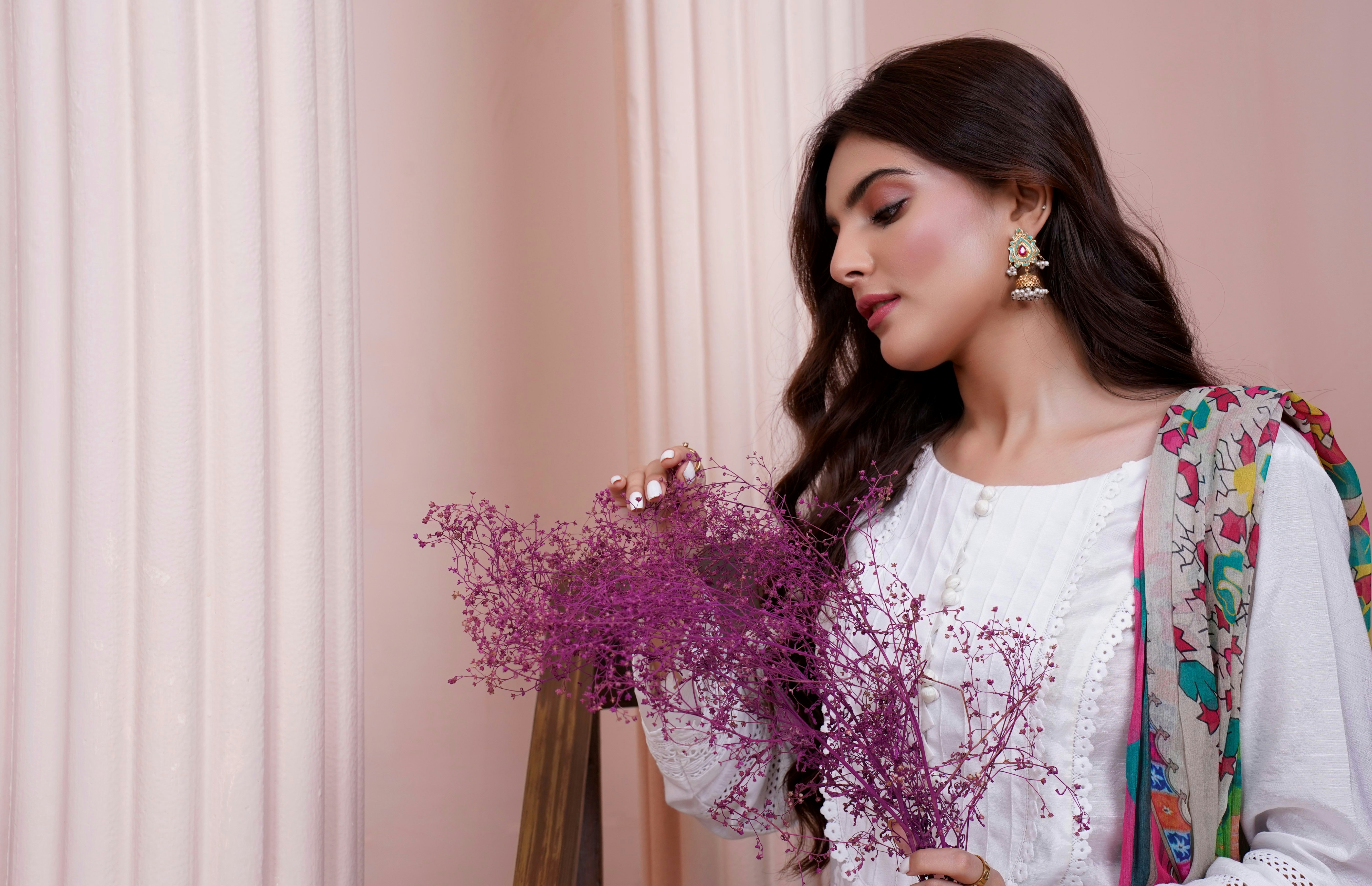 a woman holding a bouquet of purple flowers